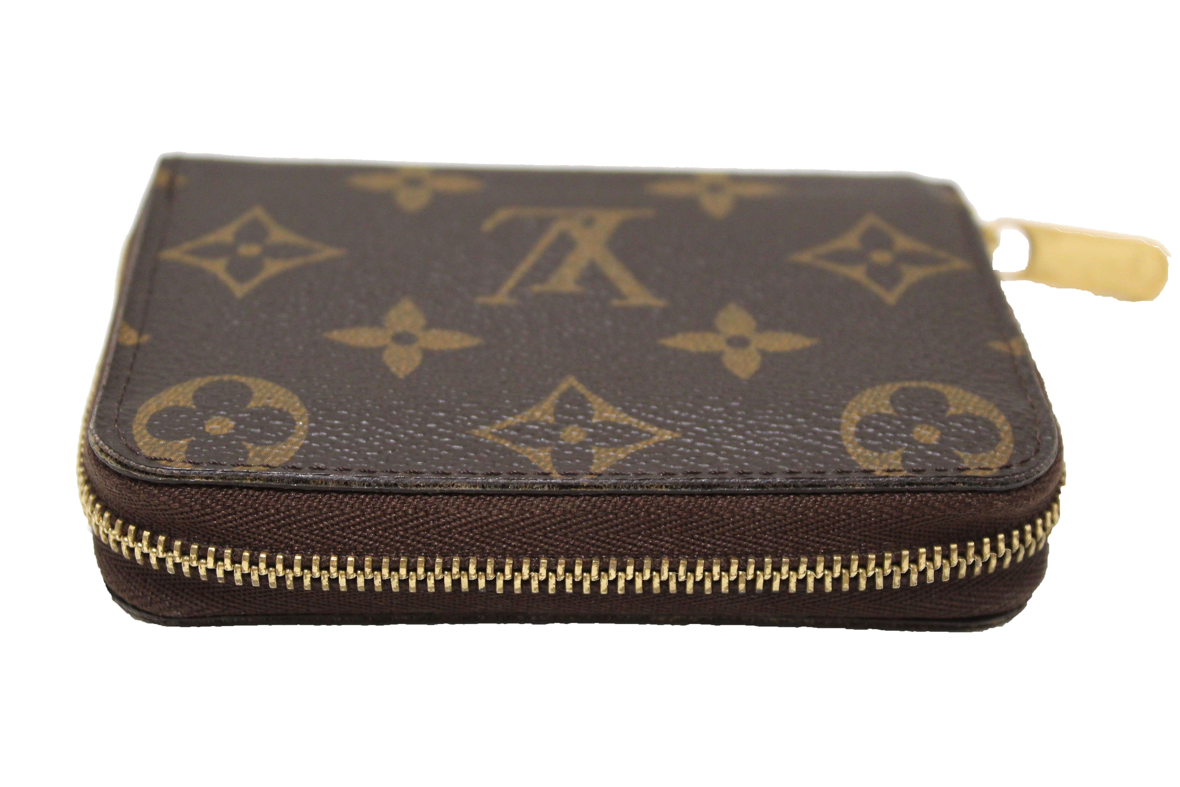A zippy coin purse perfectly positioned like a nail striking a head shaped from luxury fabric