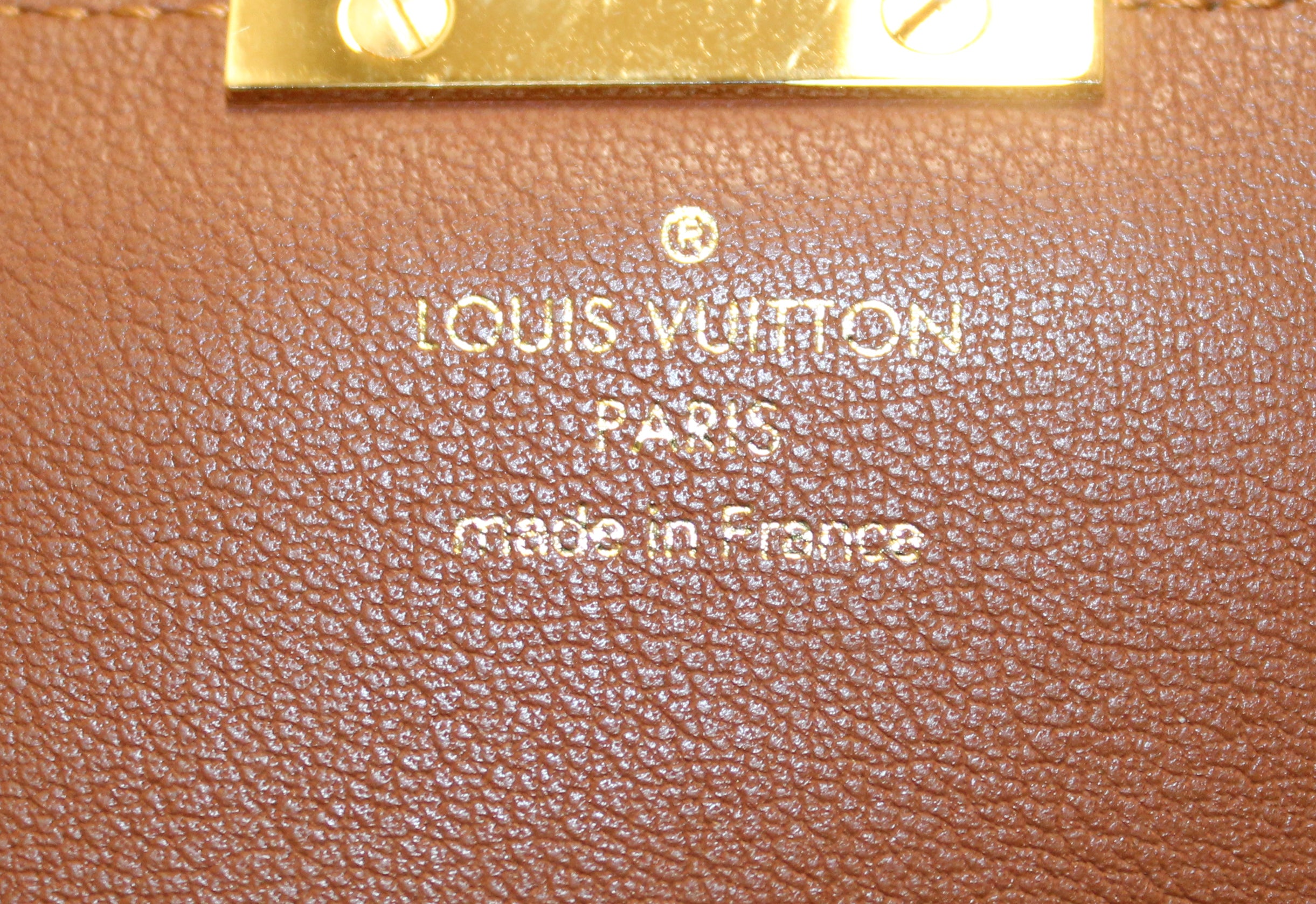 LOUIS VUITTON ELYSEE MONOGRAM WALLET, with gold tone clasp at the front and  red partitioned leather interior with a central zippered pocket and twelve  card slot panels, with dust bag, box and